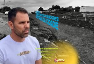 Homem em primeiro plano observa trecho da BR-265, do ano passado, em Nepomuceno, onde a enxurrada causa preocupação aos moradores na entrada da cidade.