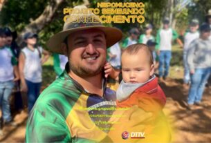 Produtor rural Juninho Pedroso segura uma criança durante visita de alunos ao seu cafezal em Nepomuceno, no Projeto Semeando Conhecimento.