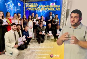 Foto do Prêmio Jovens Estrelas 2025, em Varginha-MG, mostrando os homenageados sorrindo e segurando seus troféus. À direita, o comunicador Adersen Arantes fala com emoção durante o evento. A celebração reconhece jovens talentos que inspiram amor, dedicação e transformação social.