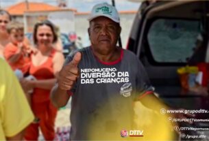 Homem distribui cachorro-quente durante ação solidária do Dia das Crianças em Nepomuceno, promovendo alegria e união entre moradores.